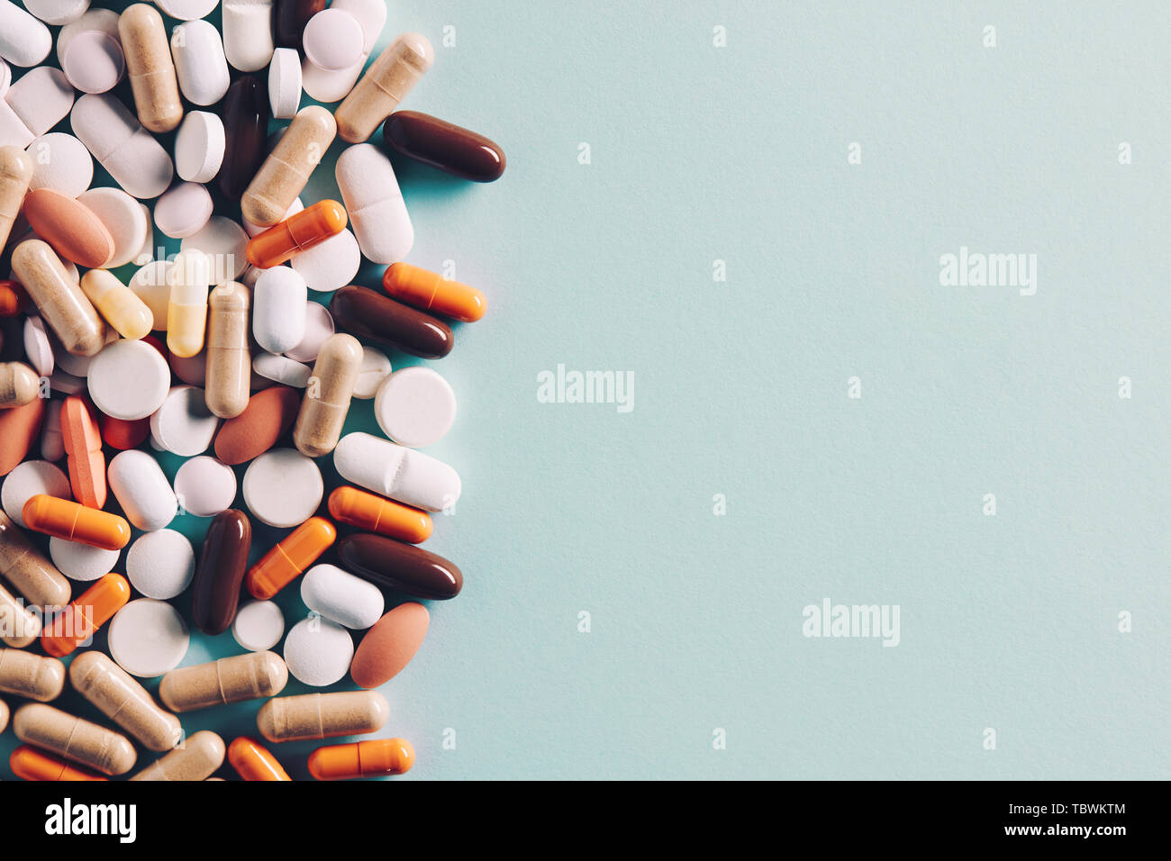 Heap of of colorful pills tablets and capsules with copy space for text. Top down view. Stock Photo