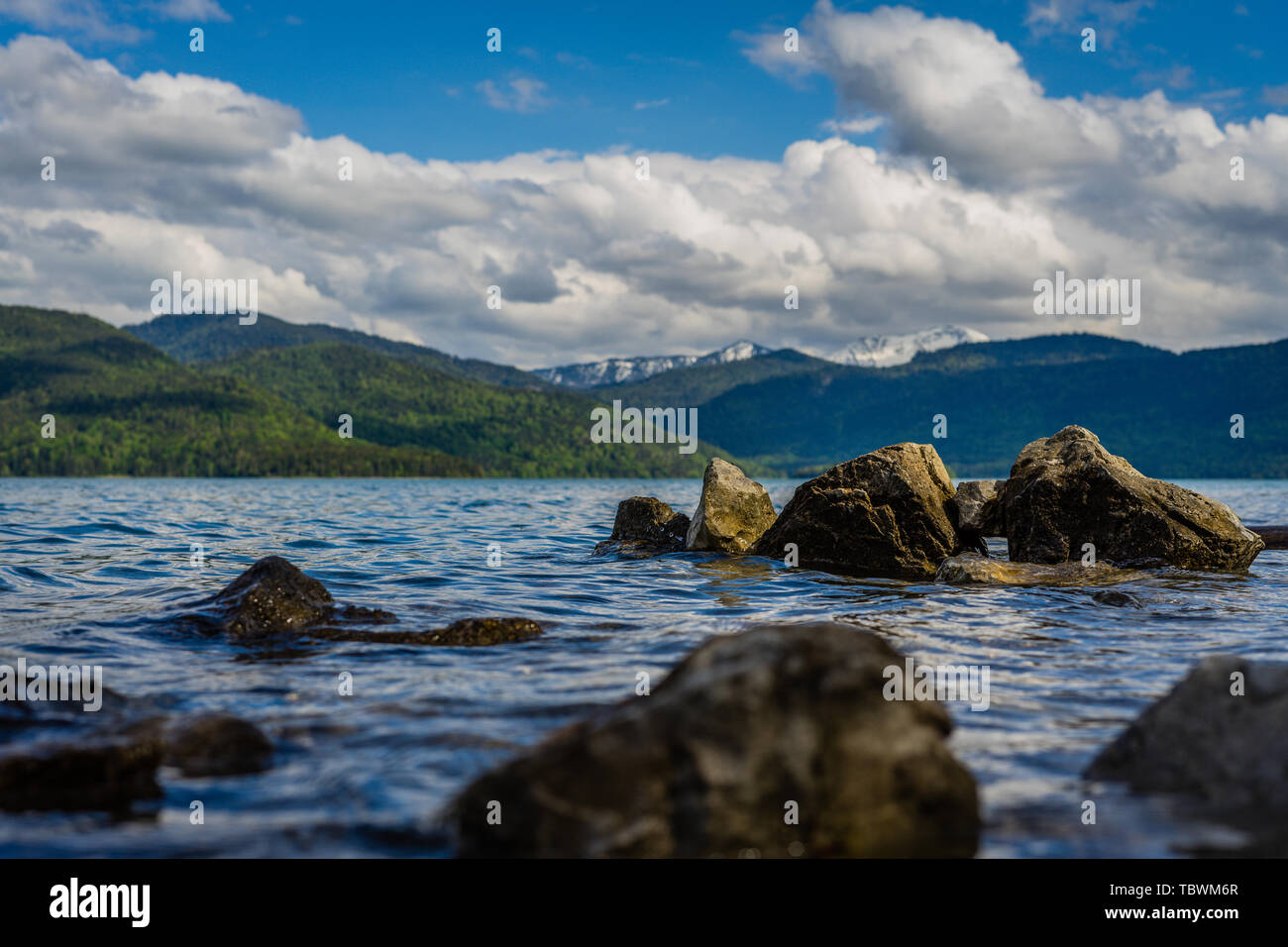 mountains, many rocks, cloudy sky, lake water Stock Photo