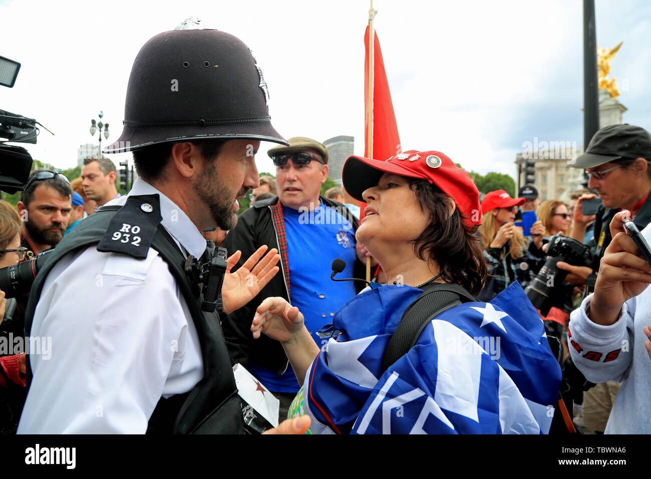 A police officer (left) intervenes to break up a heated debate between a protester and a Trump supporter (right) outside Buckingham Palace, London, during the first day of a state visit to the UK by US President Donald Trump. Stock Photo