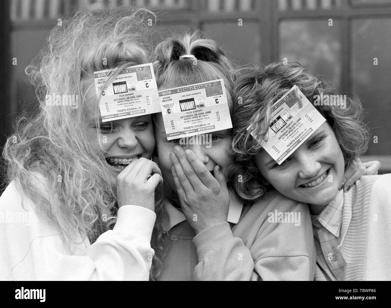 Wham! fans Jo Sayer (l), 16, and sister Katie, 13, of Dulwich, London, with Sarah Randell, 16 (r), of Beckenham, Kent, at Wembley Stadium, where they were among the first to receive tickets for the group's farewell concert at the stadium on June 28th. Stock Photo
