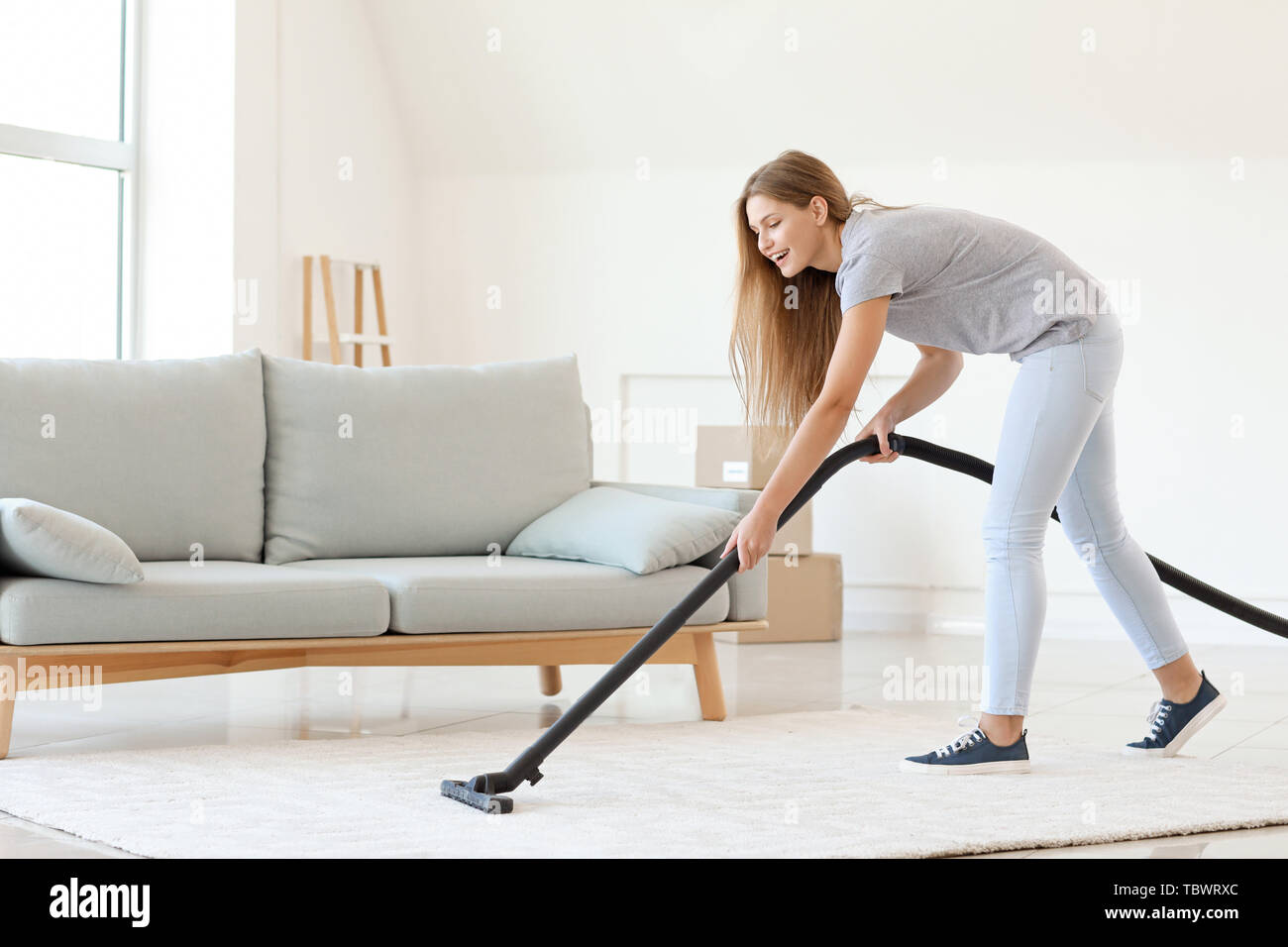 Young woman hoovering carpet at home Stock Photo Alamy