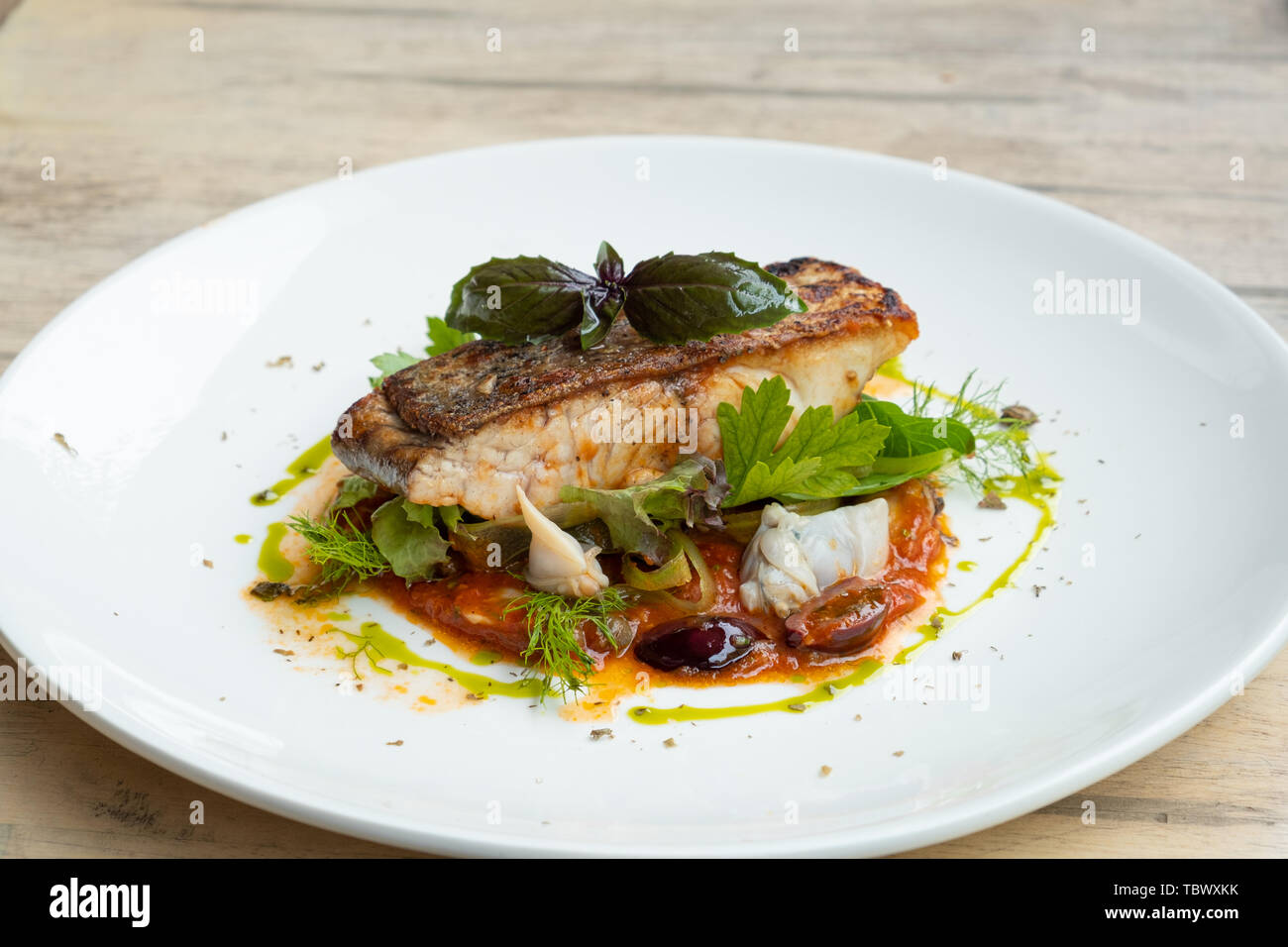 close up of pan seared grill sea bass fish fillet italian livornese