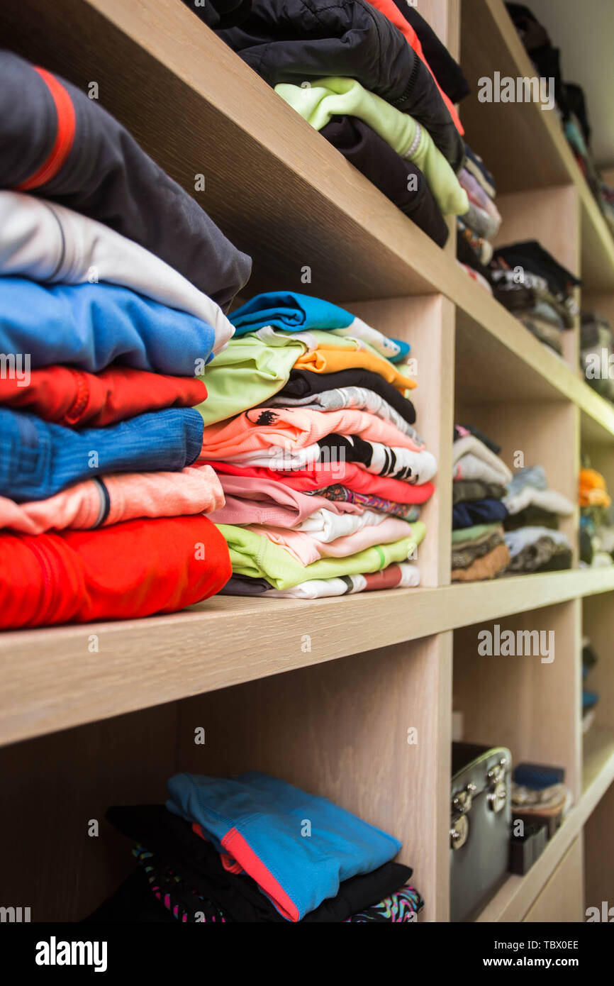 Open wardrobe with lots of folded clothes close-up Stock Photo - Alamy