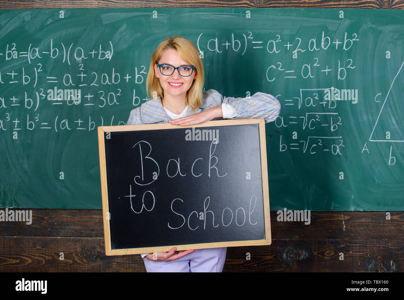 Teacher woman hold blackboard inscription back to school. It is school