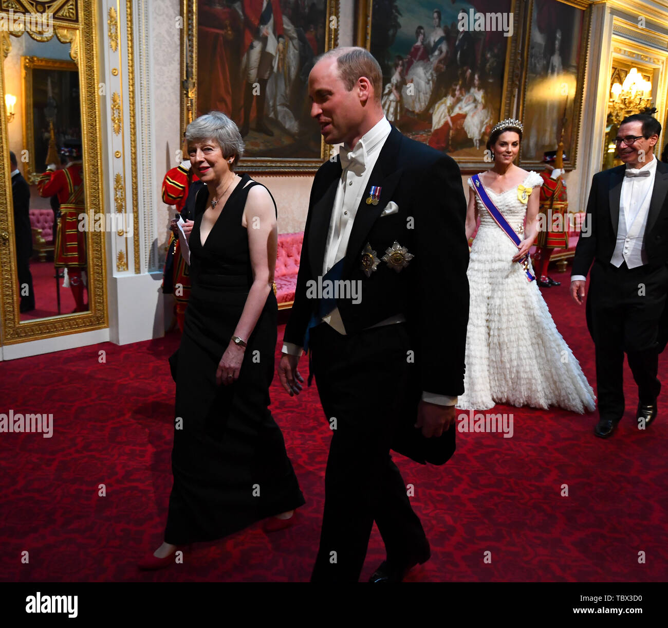 Prime Minister Theresa May and the Duke of Cambridge, followed by the Duchess of Cambridge and United States Secretary of the Treasury, Steven Mnuchin, as they arrive through the East Gallery during the State Banquet at Buckingham Palace, London, on day one of the US President's three day state visit to the UK. Stock Photo