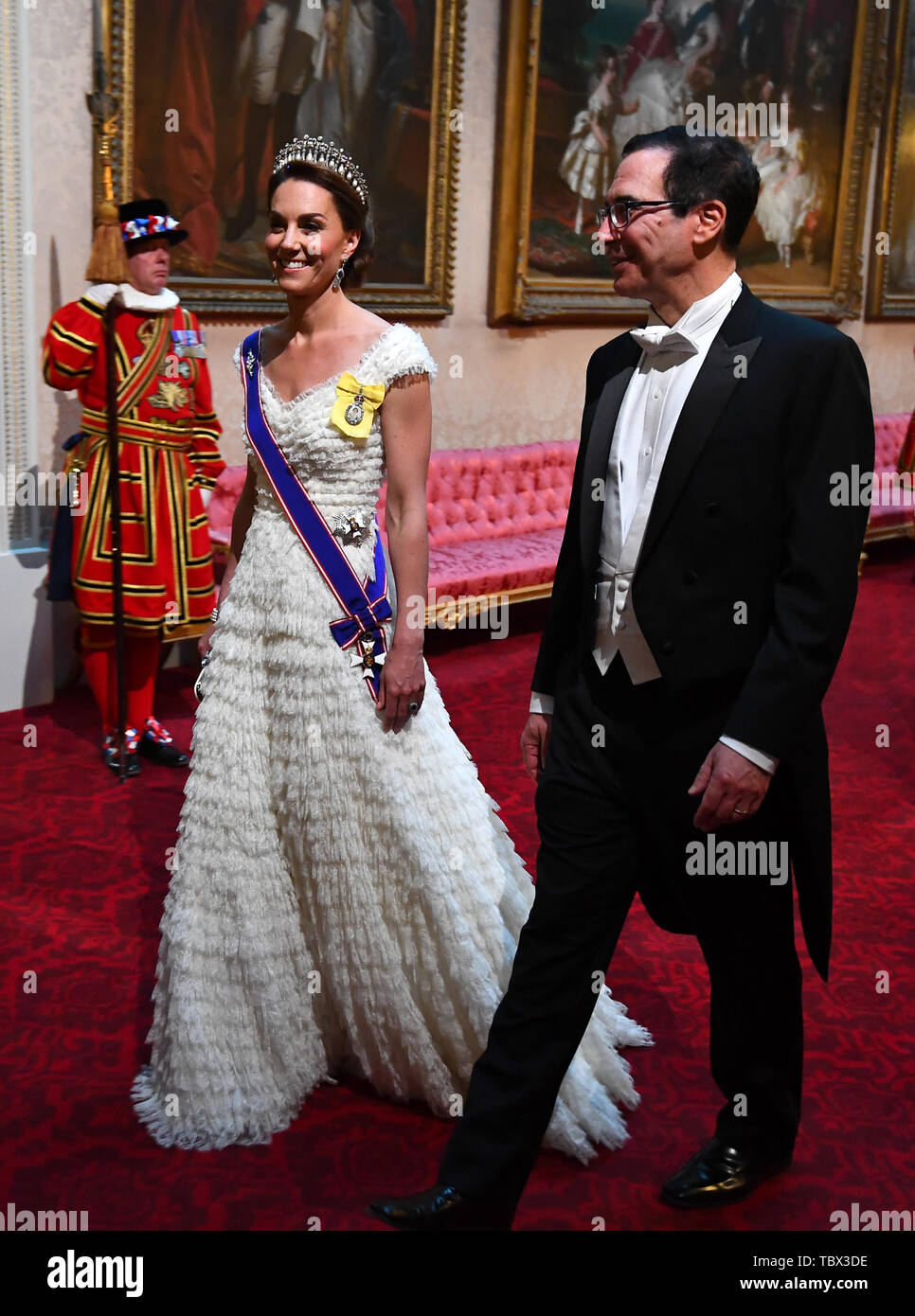 The Duchess of Cambridge and United States Secretary of the Treasury, Steven Mnuchin arrive through the East Gallery during the State Banquet at Buckingham Palace, London, on day one of the US President's three day state visit to the UK. Stock Photo