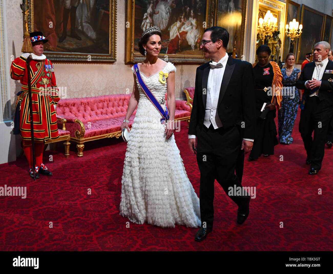 The Duchess of Cambridge and United States Secretary of the Treasury, Steven Mnuchin arrive through the East Gallery during the State Banquet at Buckingham Palace, London, on day one of the US President's three day state visit to the UK. Stock Photo