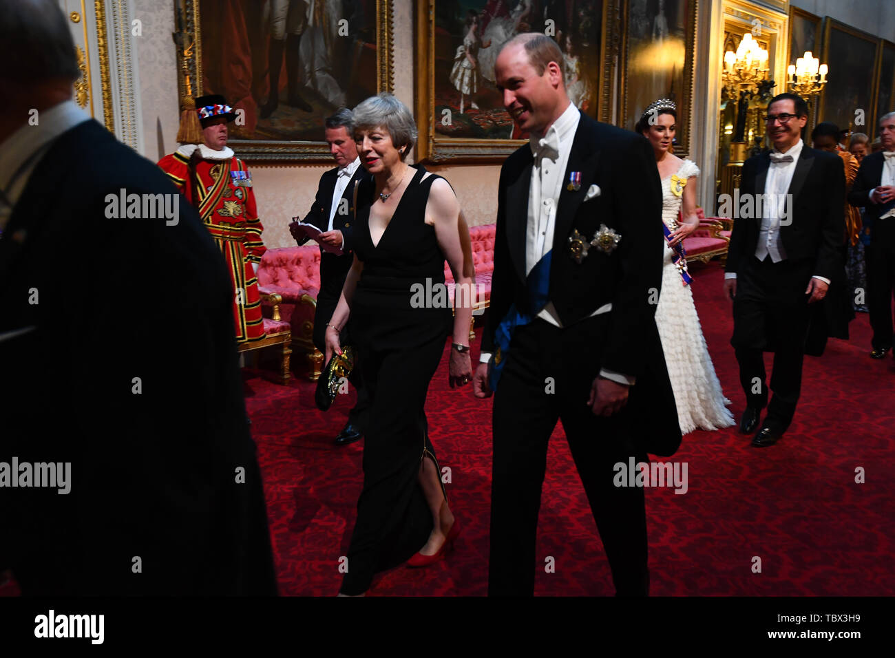 Prime Minister Theresa May and the Duke of Cambridge, followed by the Duchess of Cambridge and United States Secretary of the Treasury, Steven Mnuchin, as they arrive through the East Gallery during the State Banquet at Buckingham Palace, London, on day one of the US President's three day state visit to the UK. Stock Photo