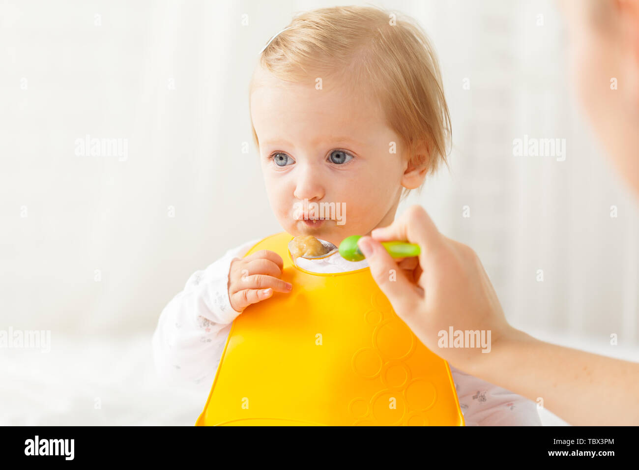 Little baby feeding with a spoon Stock Photo - Alamy