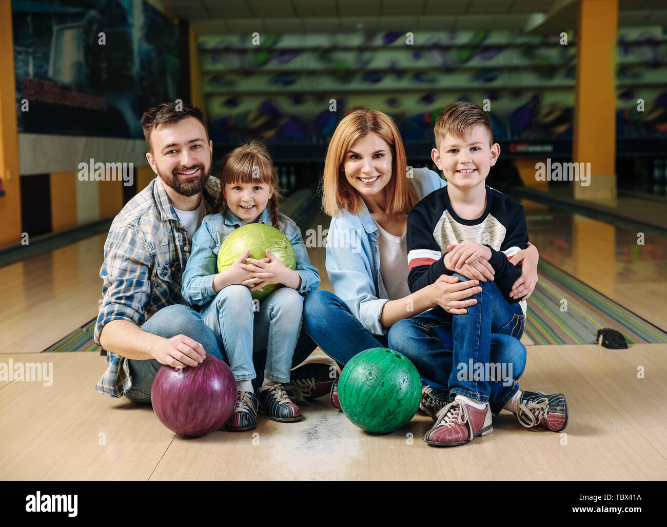 Happy family at bowling club Stock Photo