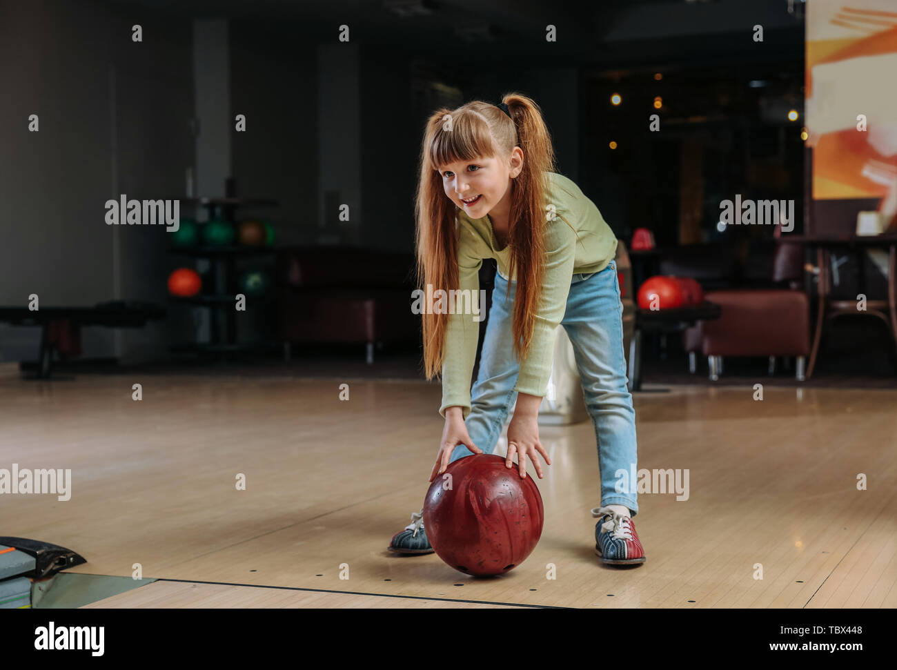 Little girl playing bowling in club Stock Photo Alamy
