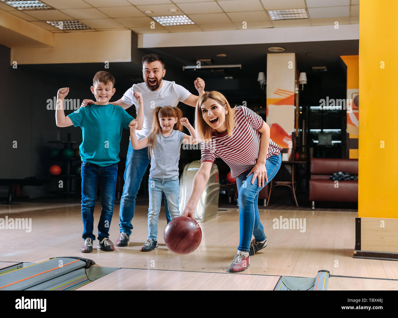 Family playing bowling in club Stock Photo