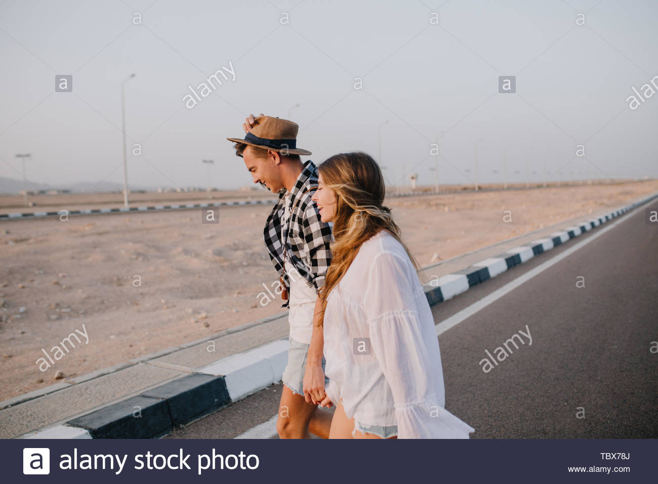 Graceful Long Haired Girl In White Shirt And Boy In Hat Walking