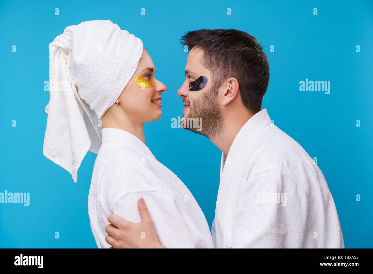 Photo on side of man and woman with gel pads under eyes and in white robe Stock Photo