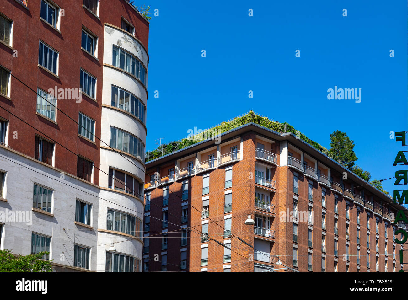 External view of an apartment building with green plants on the rooftop in Bologna, Italy Stock Photo