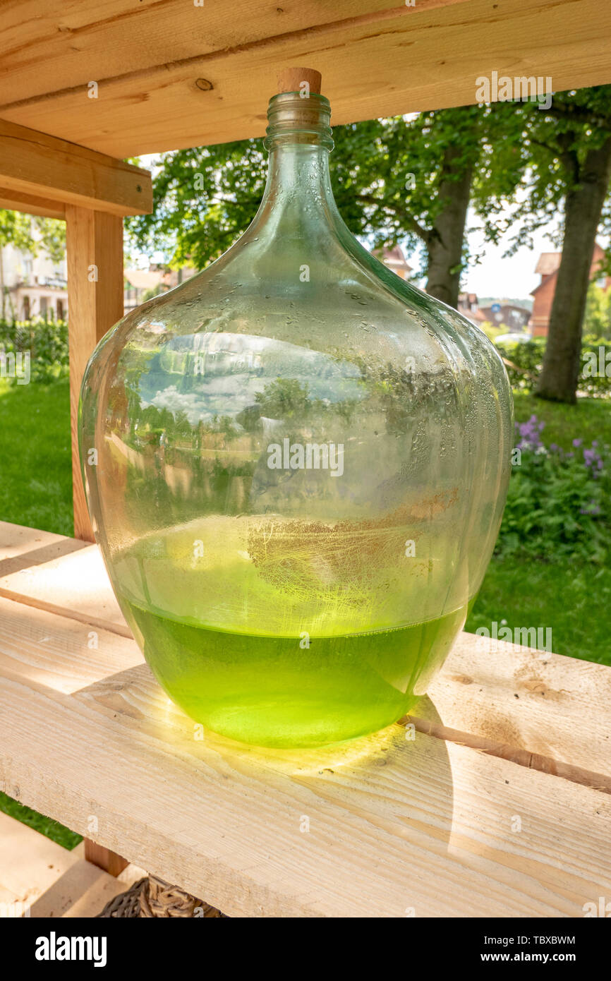 large antique glass bottle with light green liquid as medicine and