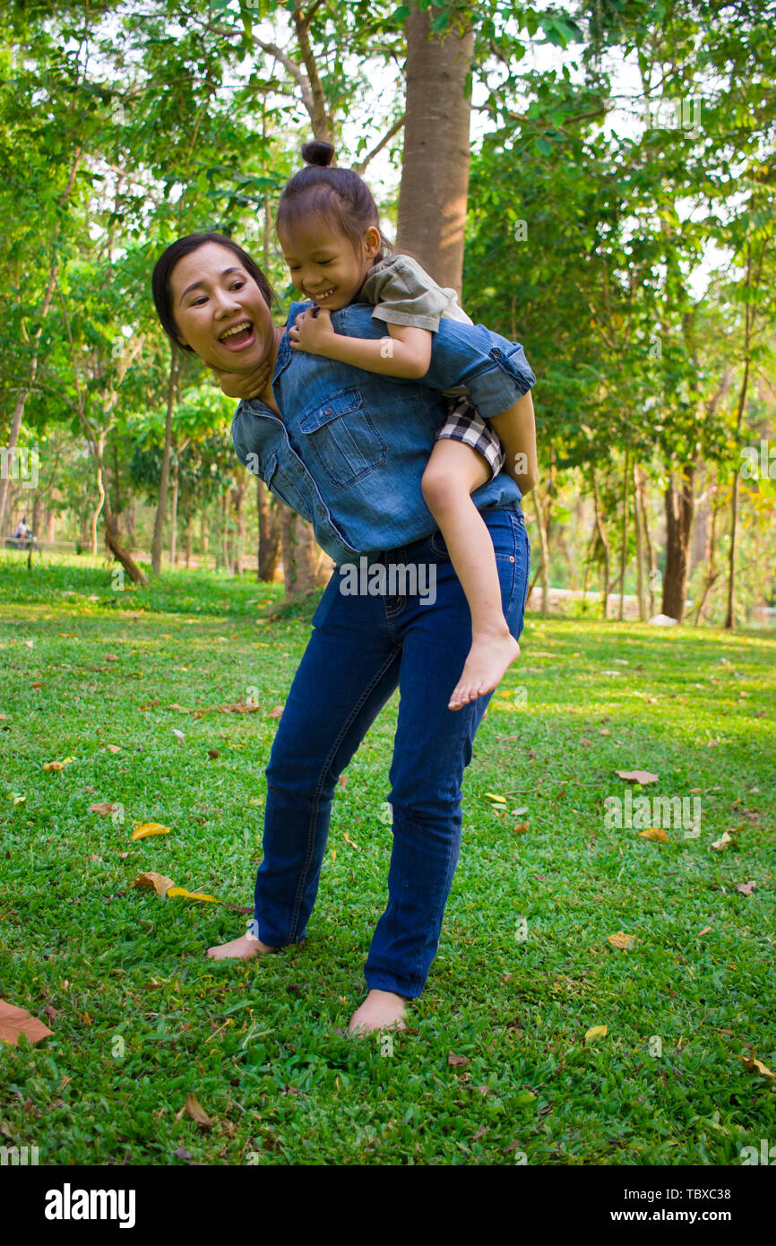 Lifestyle portrait mom and boy in happiness at the outside in the meadow, Funny Asian family in a green park High resolution image gallery. Stock Photo