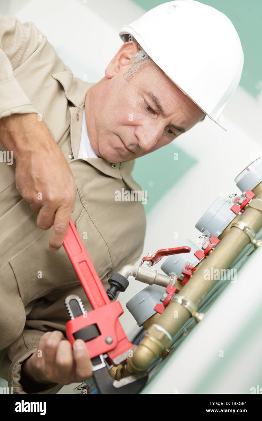 mature plumber using anjustable wrench Stock Photo Alamy