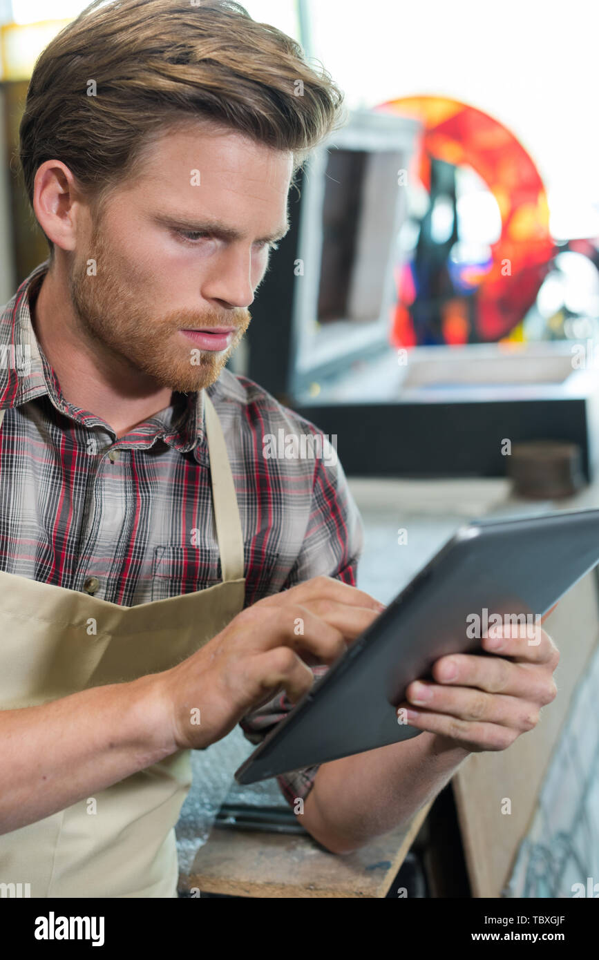 shoemaker using digital tablet in workshop Stock Photo