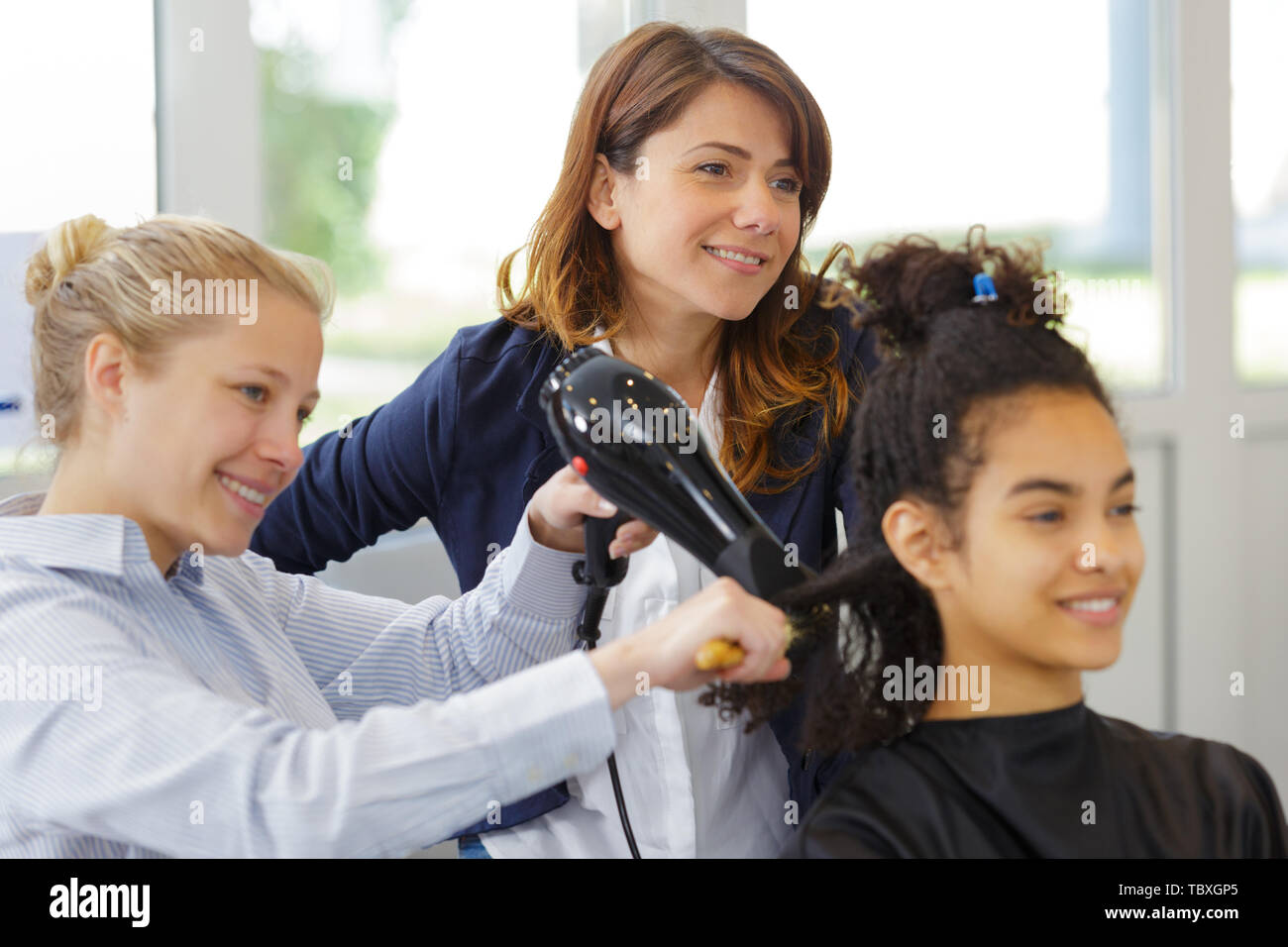 Teacher With Student Training To Become Hairdresser Stock Photo