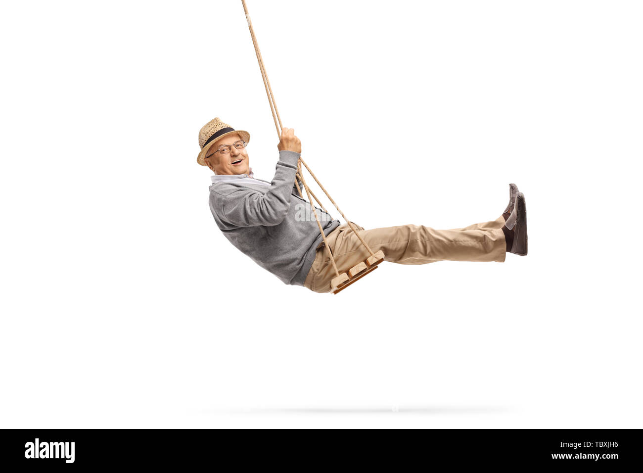 Full length shot of a happy senior swinging on a wooden swing isolated on white background Stock Photo