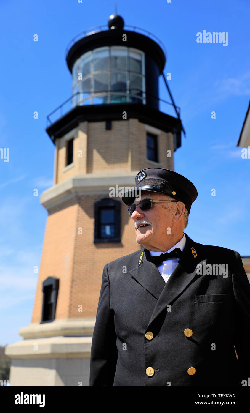 A male guide in traditional lighthouse keepers' uniform posing by the