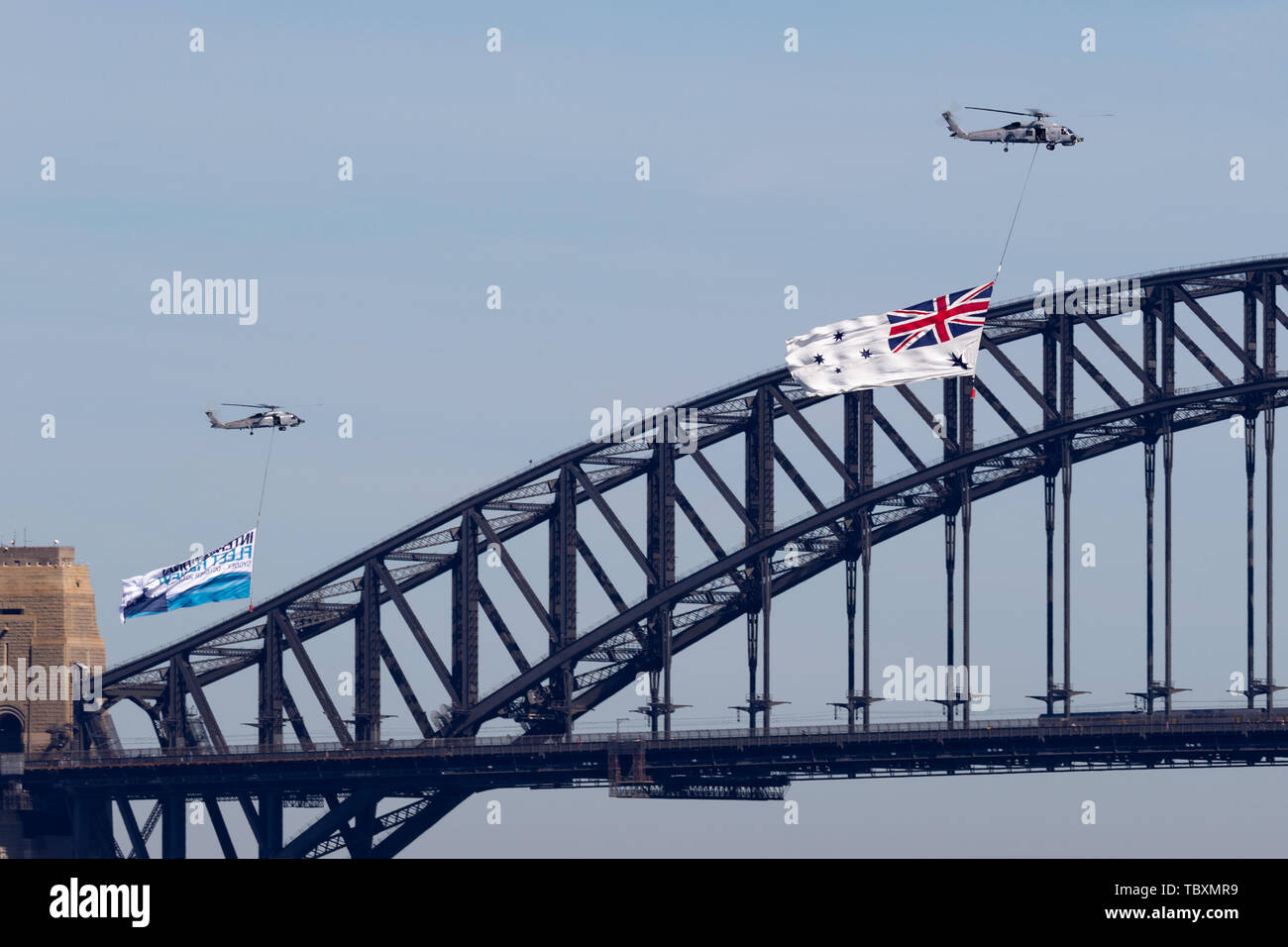 Royal Australian Navy (RAN) Sikorsky S-70B-2 Seahawk Helicopter N24-001 flying the White Ensign of the RAN over Sydney Harbour. Stock Photo