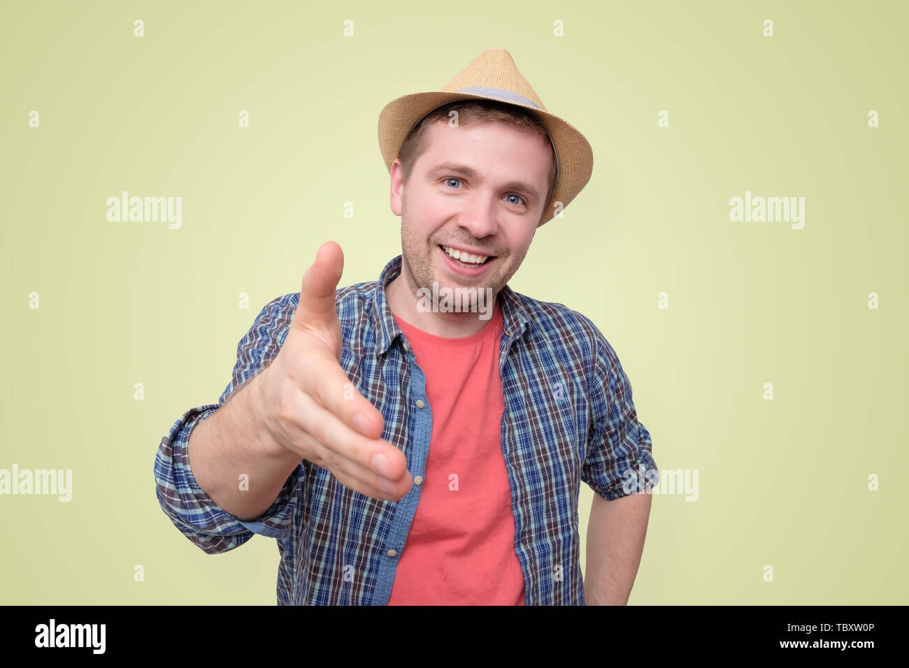 Young man in summer hat shake hand with you Stock Photo