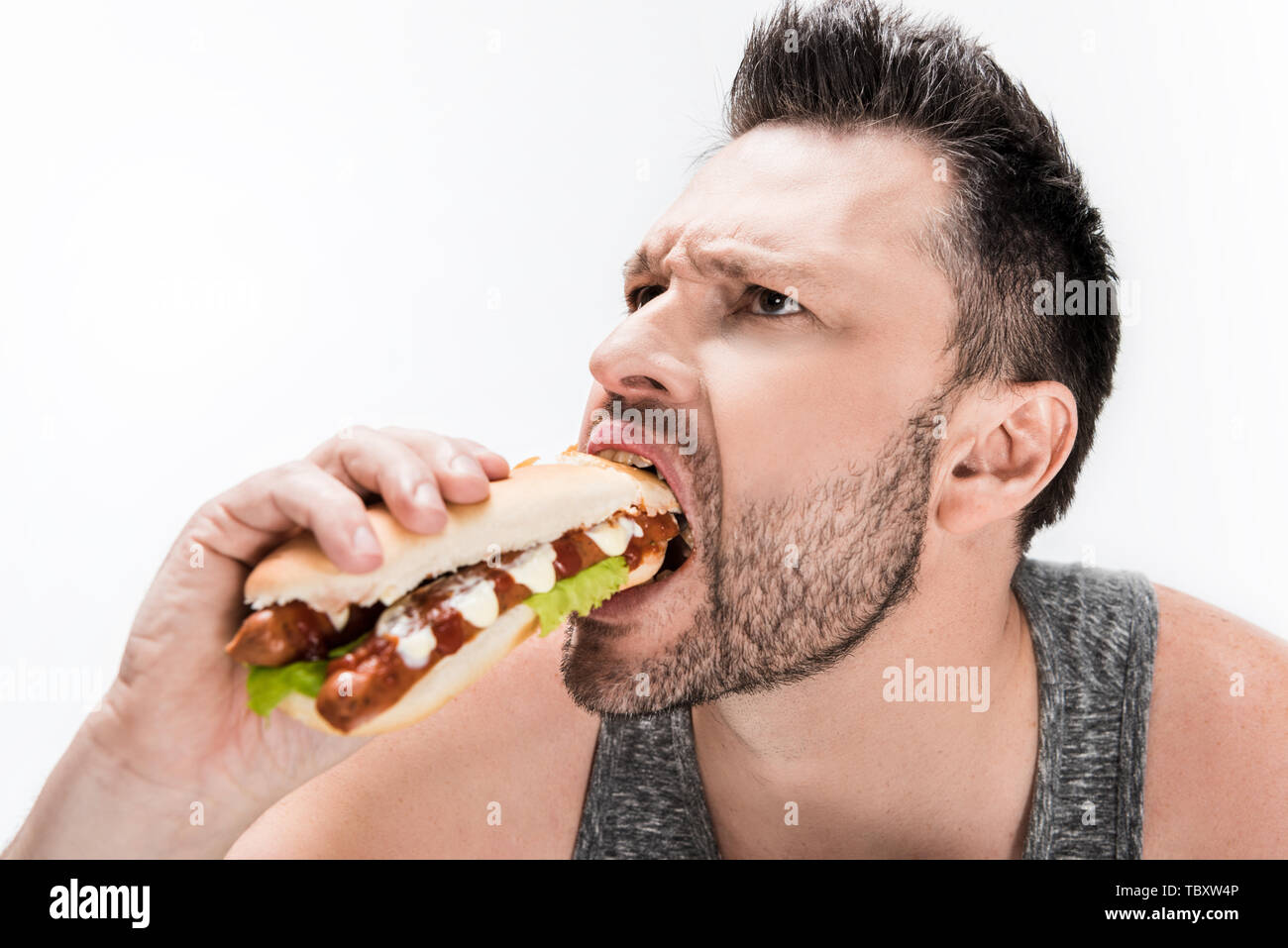 overweight bearded man eating hot dog isolated on white Stock Photo