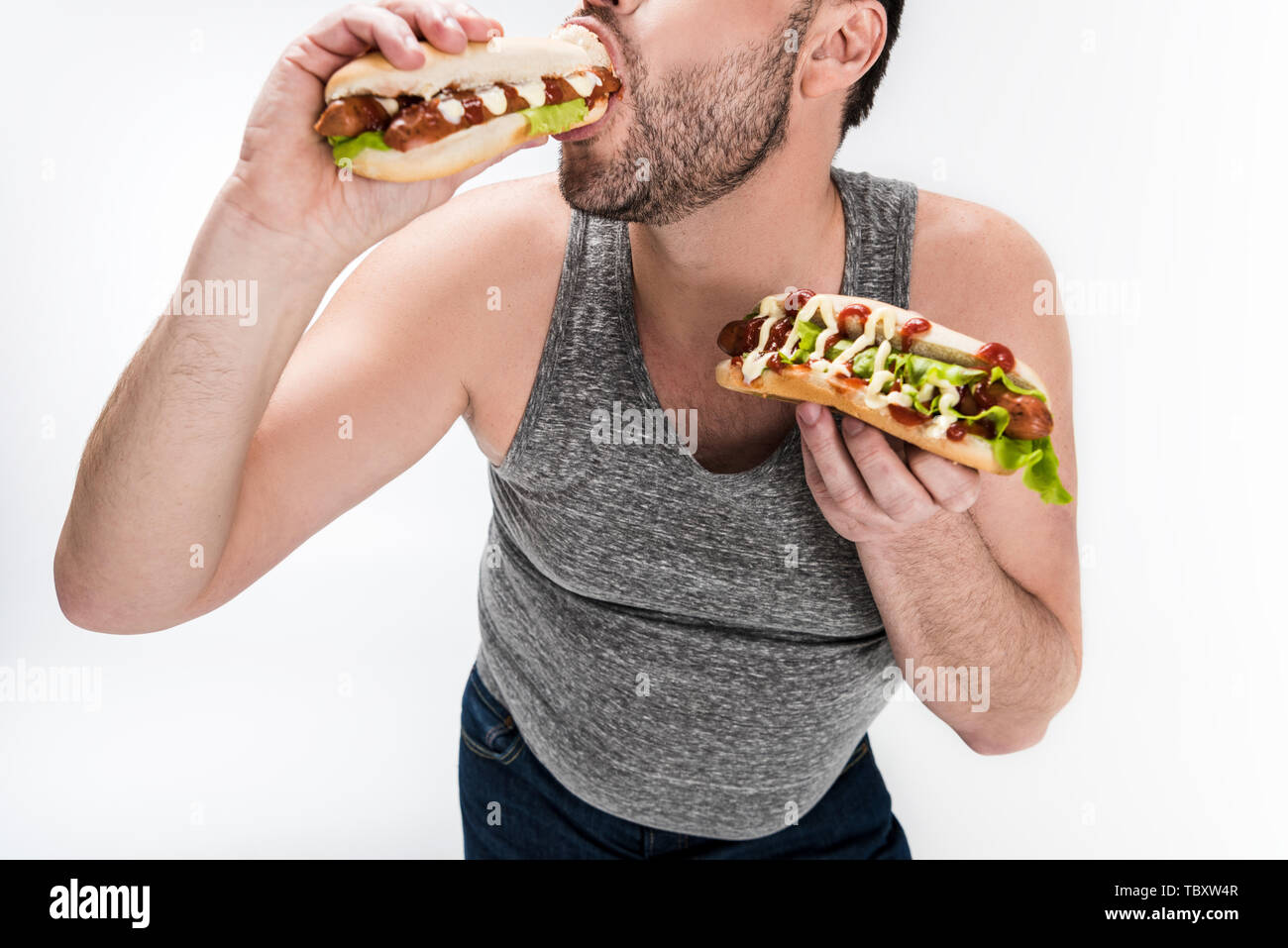 cropped view of overweight man eating hot dog isolated on white Stock Photo