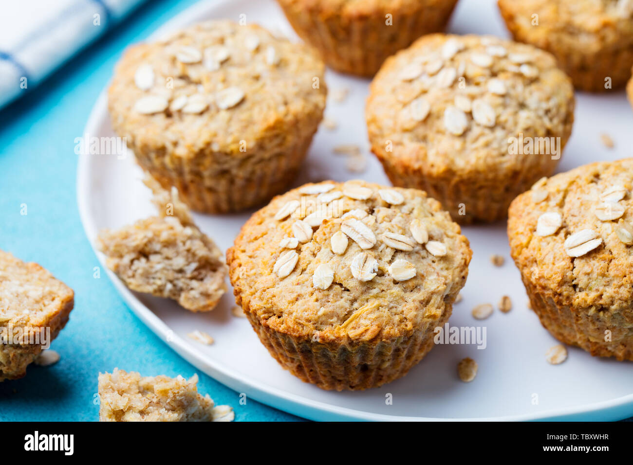 Healthy vegan oat muffins, apple and banana cakes on a white plate. Blue background. Stock Photo