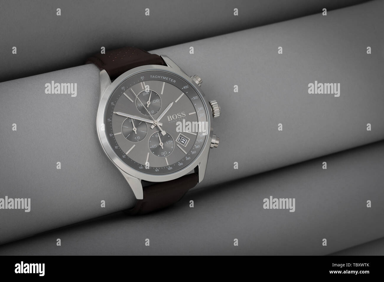 Hugo Boss stylish designer watch photographed with rolls of grey material. Stock Photo