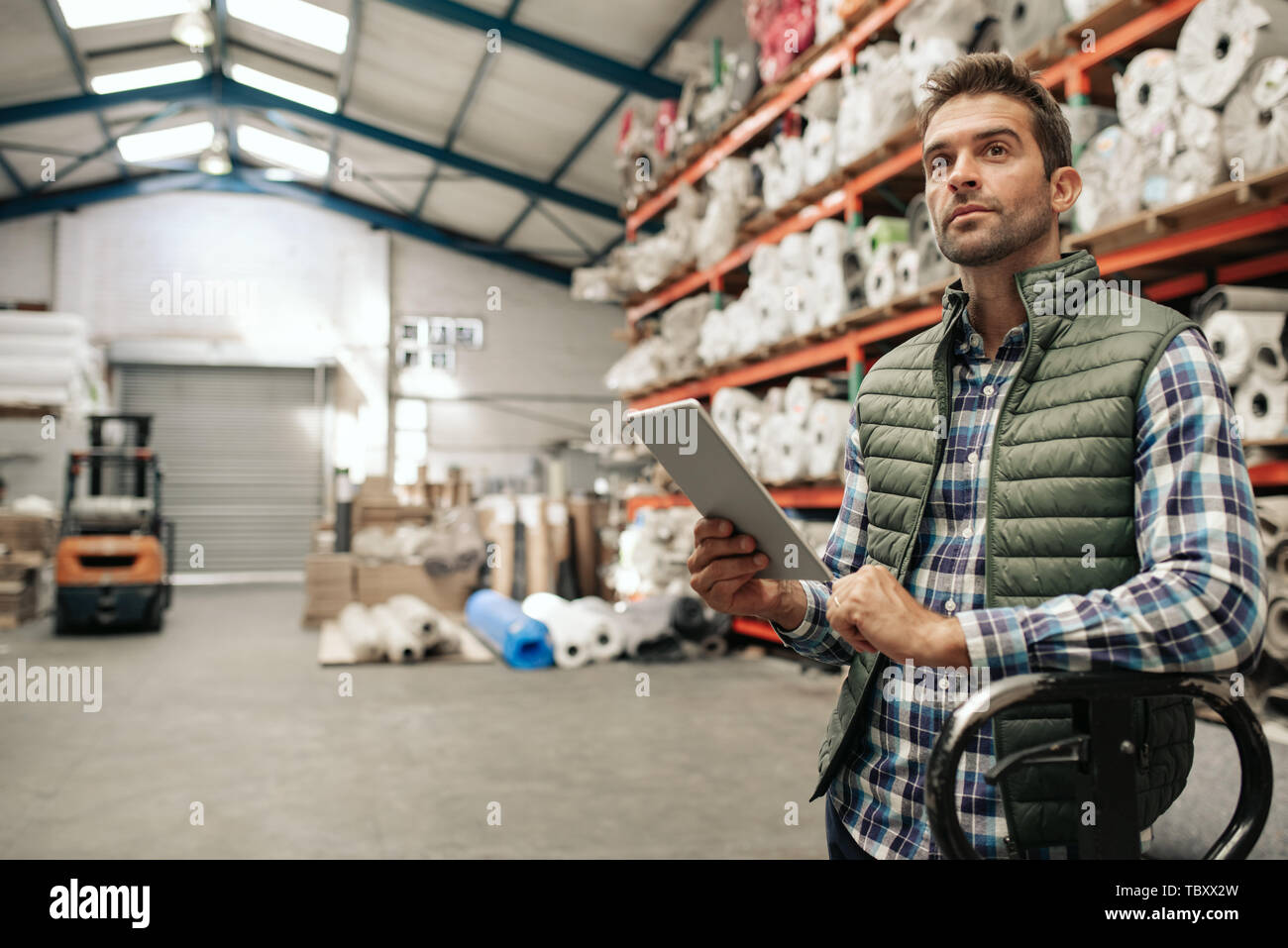 Warehouse worker checking stock using a digital tablet Stock Photo