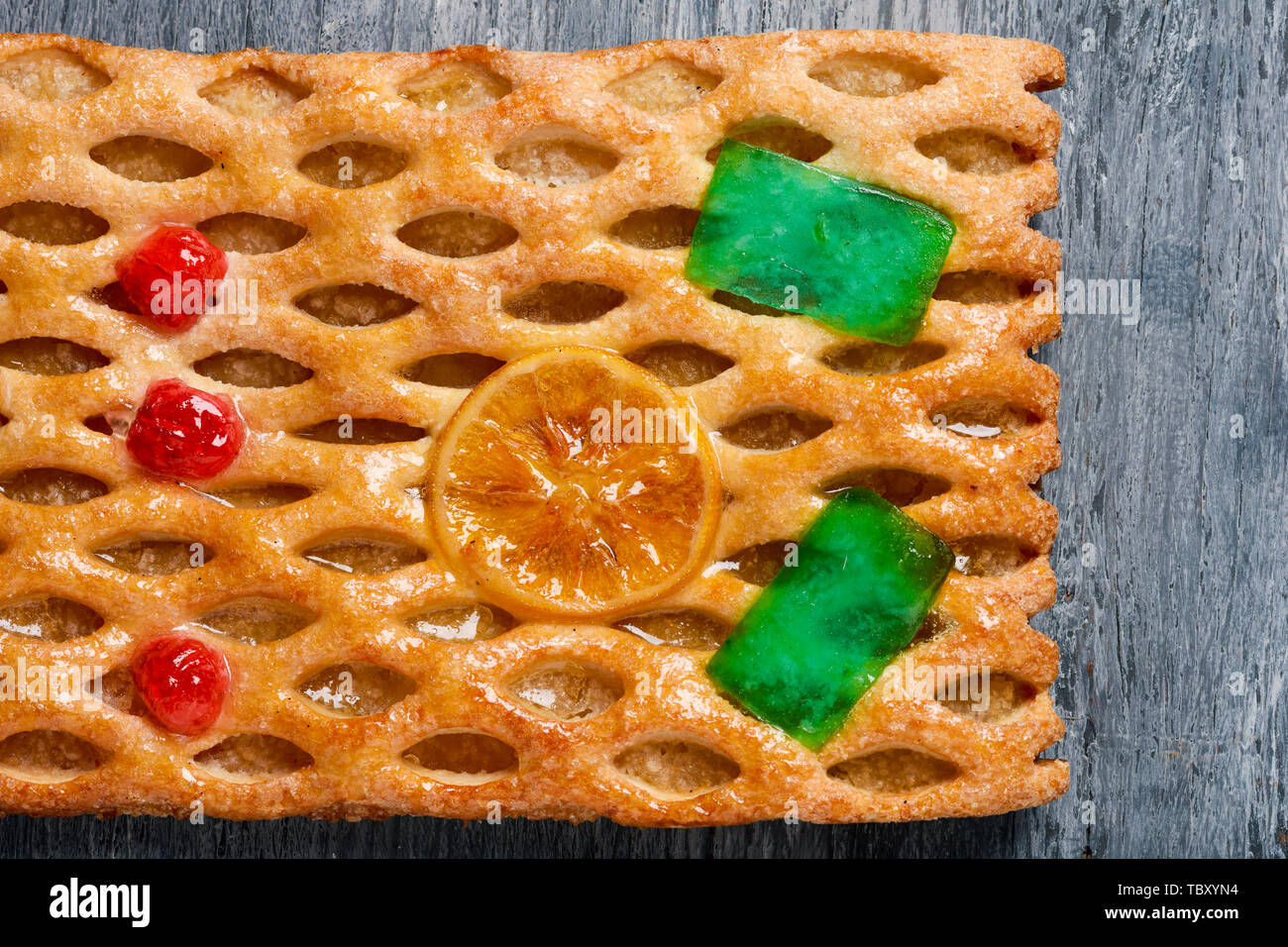 high angle view of a coca de Sant Joan, a typical sweet flat cake from Catalonia, Spain, eaten on Saint Johns Eve, on a gray rustic table Stock Photo