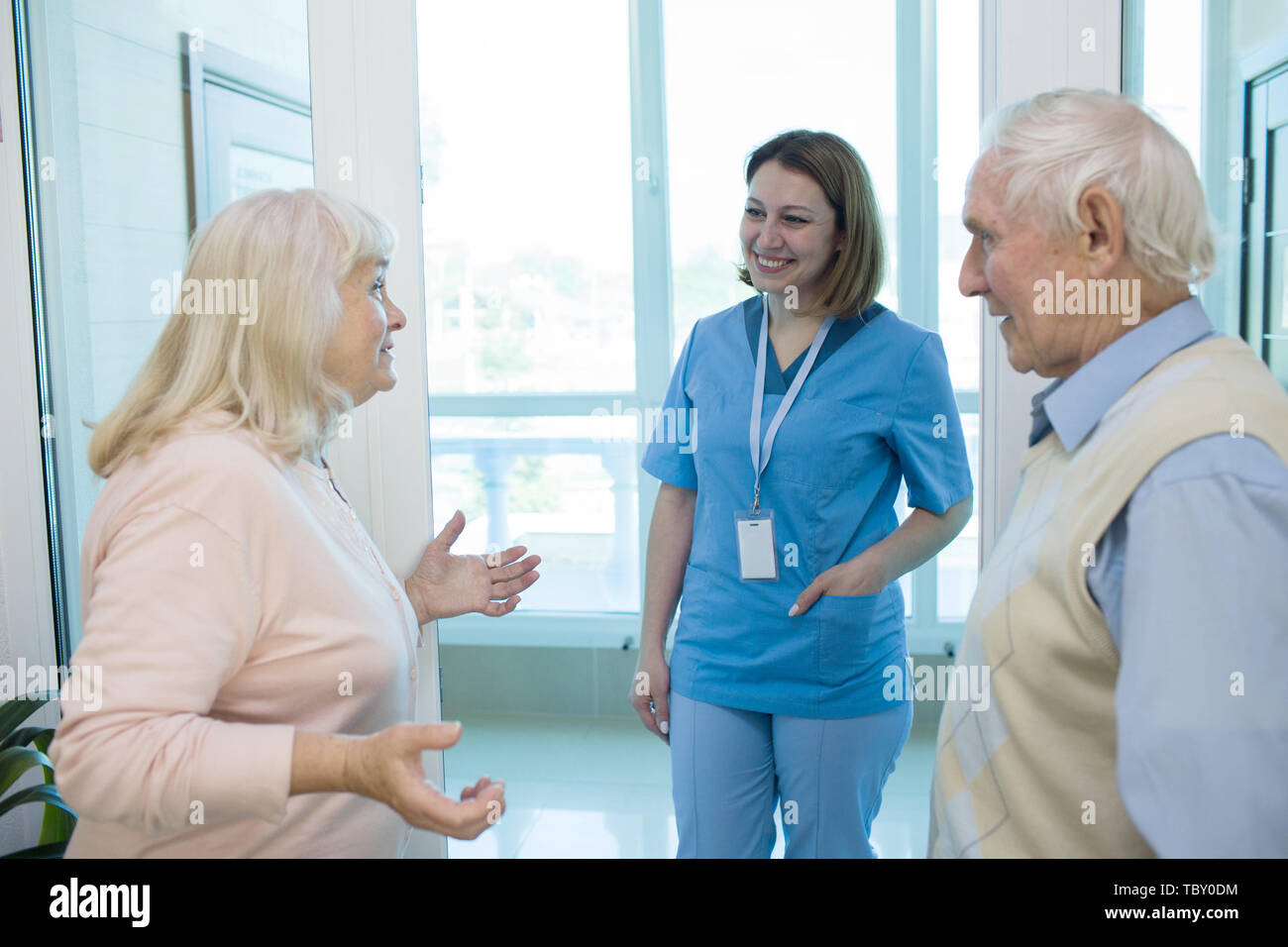 Nurse talking with senior people in retirement home. Stock Photo