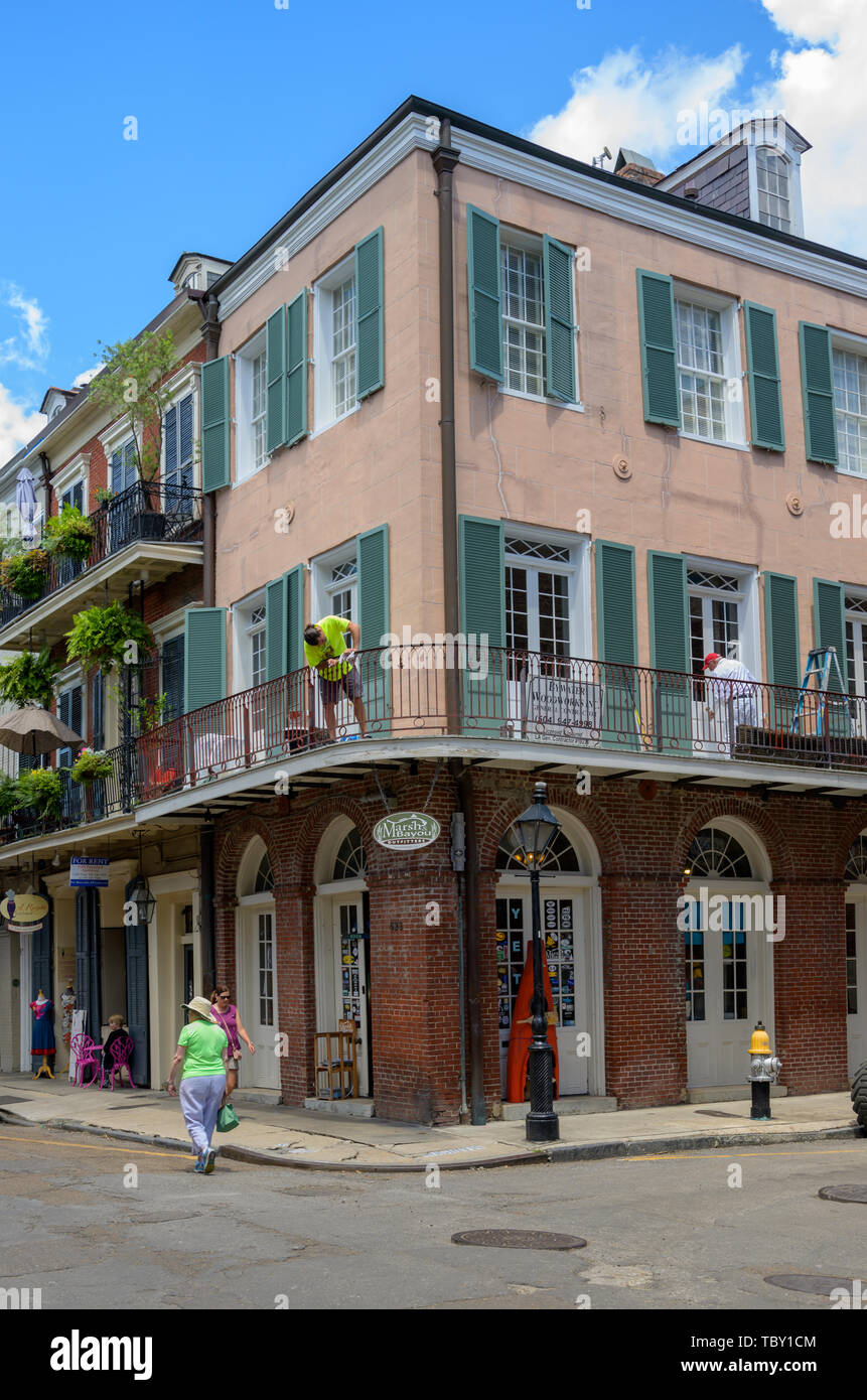 New Orleans, LA, USA -- May 23, 2019.  A woman walks past a retail store by  Jackson Square, New Orleans; workers are doing repair work on the second Stock Photo