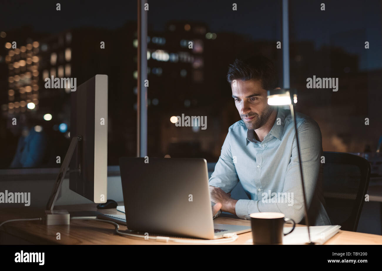 Young businessman working overtime late in the evening Stock Photo