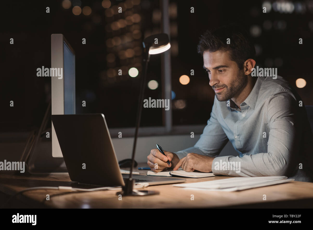 Young businessman writing down notes while working at night Stock Photo