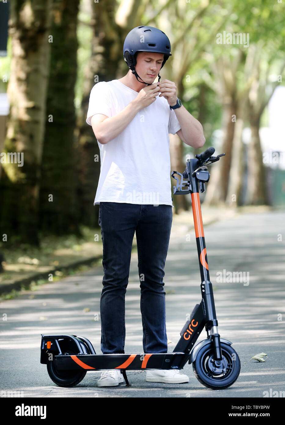Herne, Germany. 04th June, 2019. Circ employee Max Brenssell puts on a helmet for a test drive with the Circ e-scooter (previously Flash). Even before electric pedal-scooters are allowed nationwide on 15 June, a first provider will start a rental service in the Ruhr area. In the city of Herne, several dozens of electric scooters are to be put on the road from 05.06.2019 with the permission of the local authorities. (to dpa 'First supplier of electric scooters starts in Herne') Credit: Roland Weihrauch/dpa/Alamy Live News Stock Photo