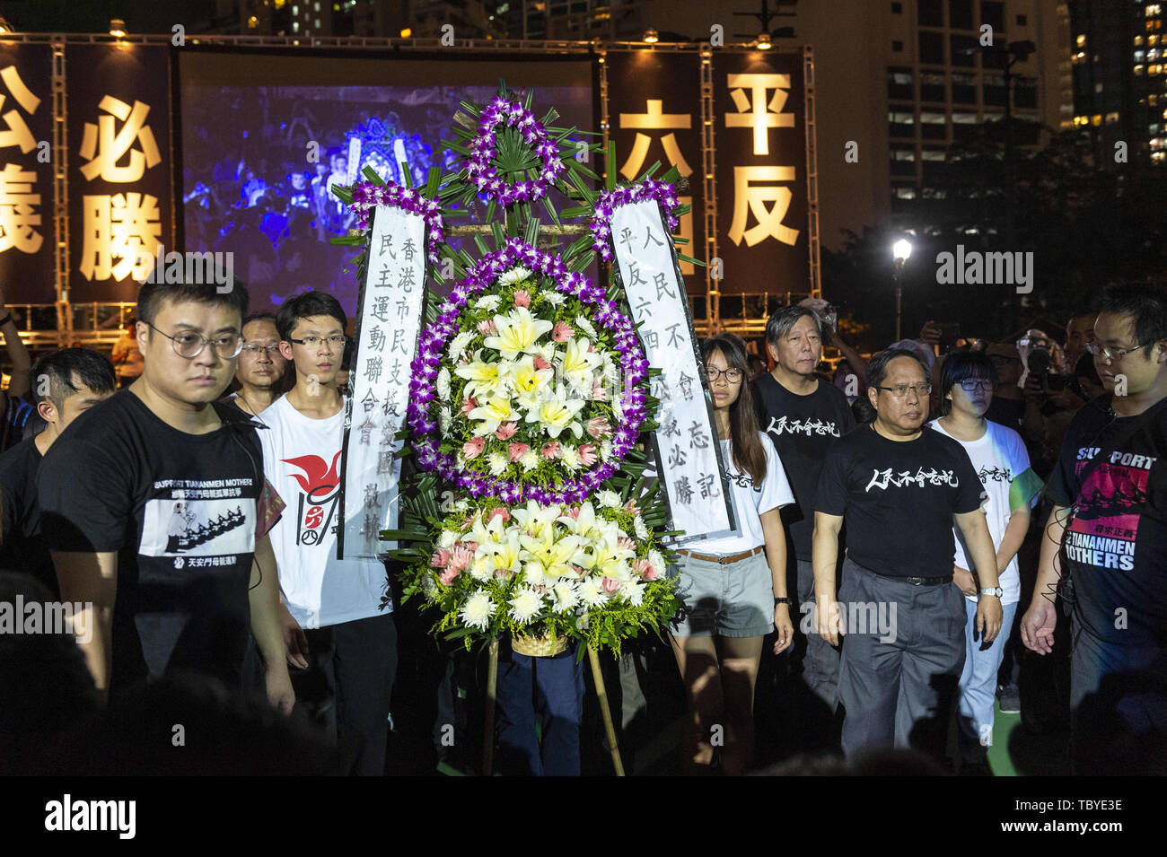 Hong Kong, Hong Kong SAR, CHINA. 4th June, 2019. Students march the wreath to the memorial cenotaph.A candlelit vigil takes place in Hong Kong's Victoria Park to mark the 30th Anniversary of the Tiananmen Square massacre in Beijing China in 1989.As the only location on Chinese soli that such a rally is allowed, the crowds are overflowing people fear the ever deteriorating human rights in China. Credit: Jayne Russell/ZUMA Wire/Alamy Live News Stock Photo