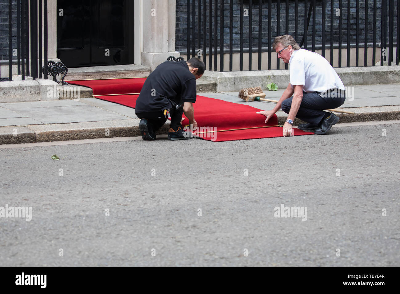 London, UK. 4th June, 2019. Two men Roll out the red carpet ready for the arrival of President Trump in Downing Street. Credit: Keith Larby/Alamy Live News Stock Photo