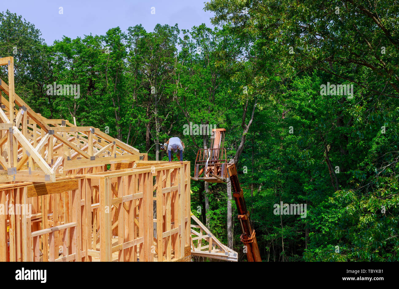 Looking up at new construction beams under a clear blue sky with ...