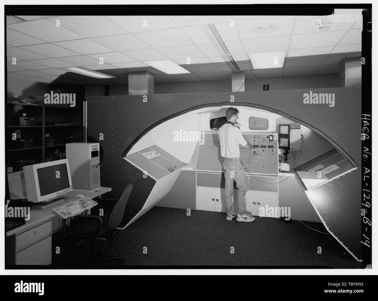 NBS REMOTE MANIPULATOR SIMULATOR (RMS) CONTROL ROOM. THE RMS CONTROL PANEL IS IDENTICAL TO THE SHUTTLE ORBITER AFT FLIGHT DECK WITH ALL RMS SWITCHES AND CONTROL KNOBS FOR INVOKING ANY POSSIBLE FLIGHT OPERATIONAL MODE. THIS INCLUDES ALL COMPUTER AIDED OPERATIONAL MODES, AS WELL AS FULL MANUAL MODE. THE MONITORS IN THE AFT FLIGHT DECK WINDOWS AND THE GLASSES THE OPERATOR WEARS PROVIDE A 3D VIDEO PICTURE TO AID THE OPERATOR WITH DEPTH PERCEPTION WHILE OPERATING THE ARM. THIS IS REQUIRED BECAUSE THE RMS OPERATOR CANNOT VIEW RMS MOVEMENTS IN THE WATER WHILE AT THE CONTROL PANEL.  Marshall Space Fli Stock Photo