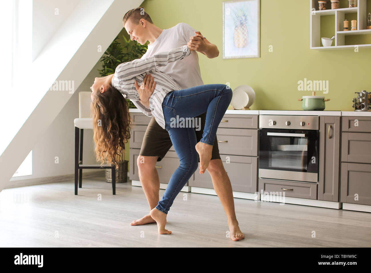 Adorable loving couple dancing in kitchen at home Stock Photo