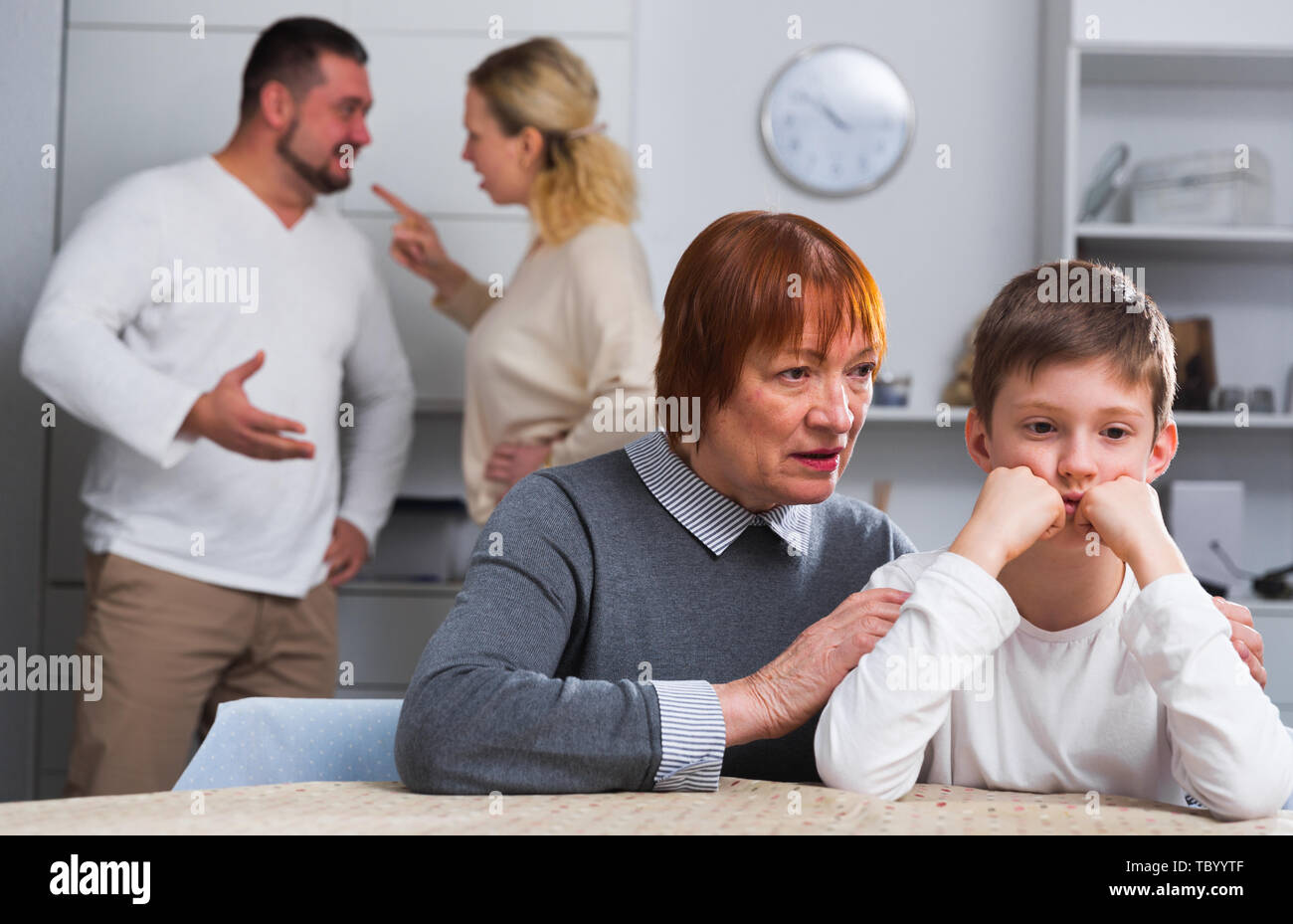 Senior woman calming chagrined boy during his parents quarrel Stock ...