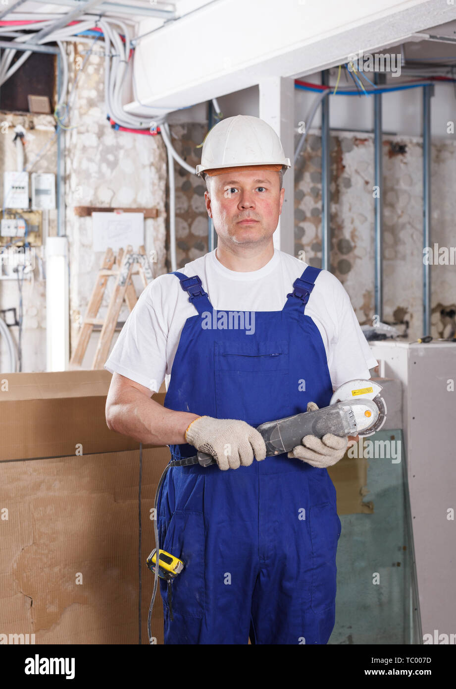 Construction worker using handheld circular saw at indoors building site Stock Photo
