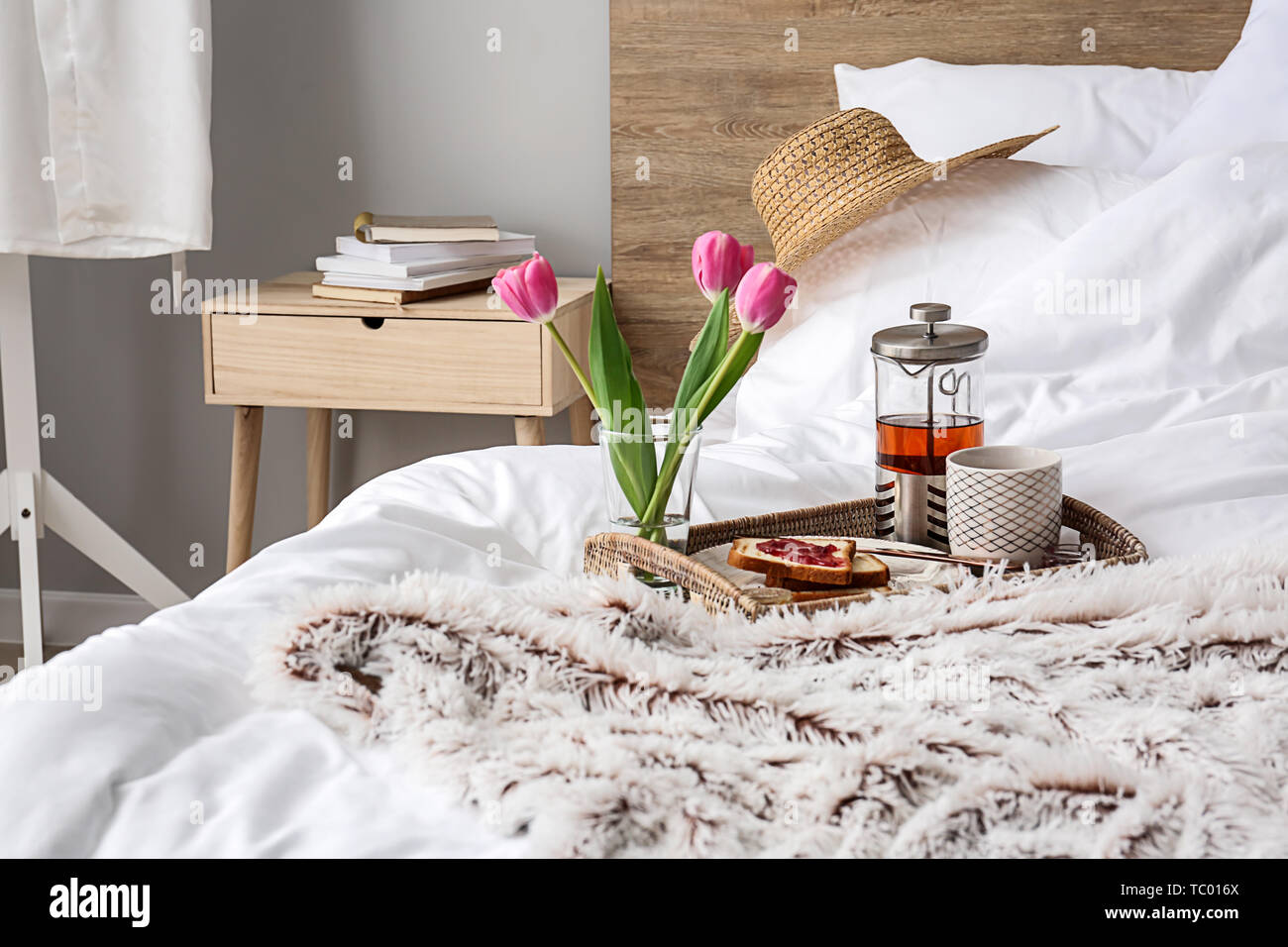 Tray with tasty breakfast on bed Stock Photo