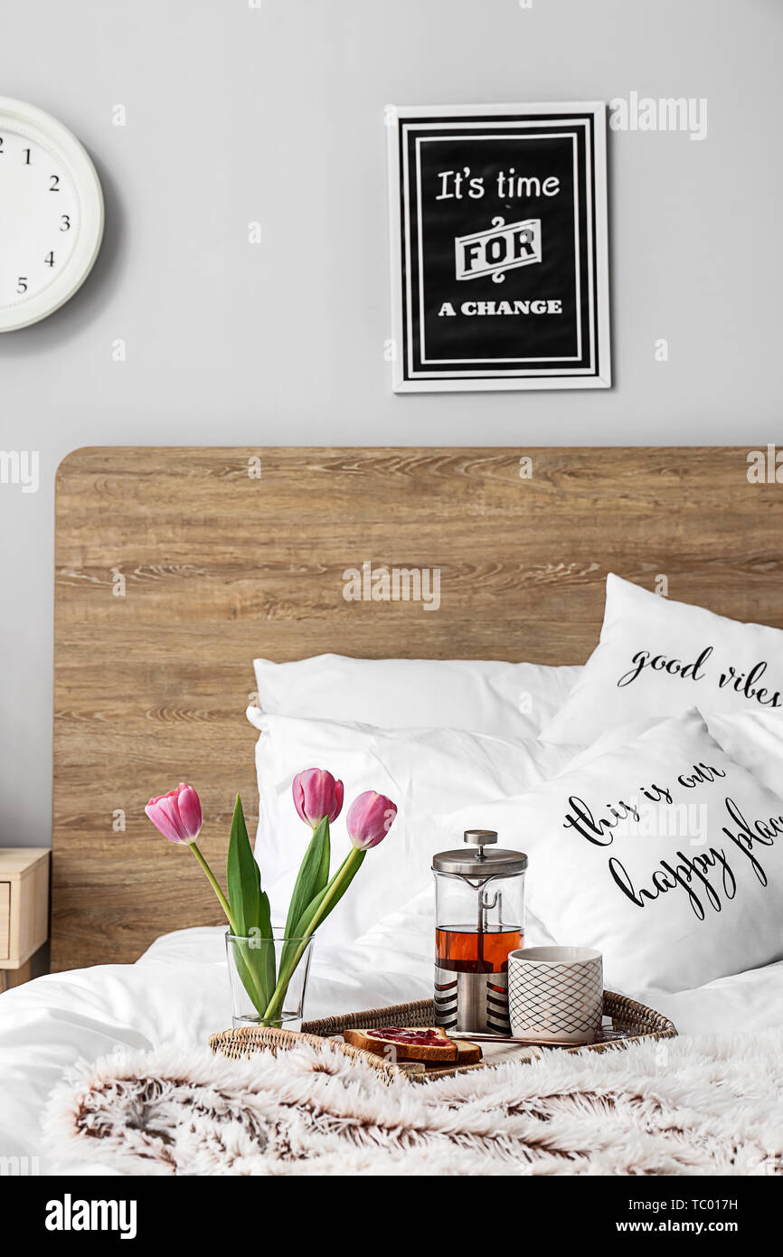 Tray with tasty breakfast on bed Stock Photo