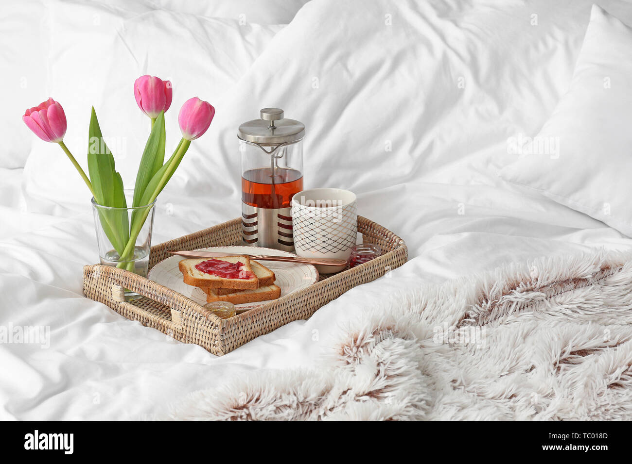 Tray with tasty breakfast on bed Stock Photo