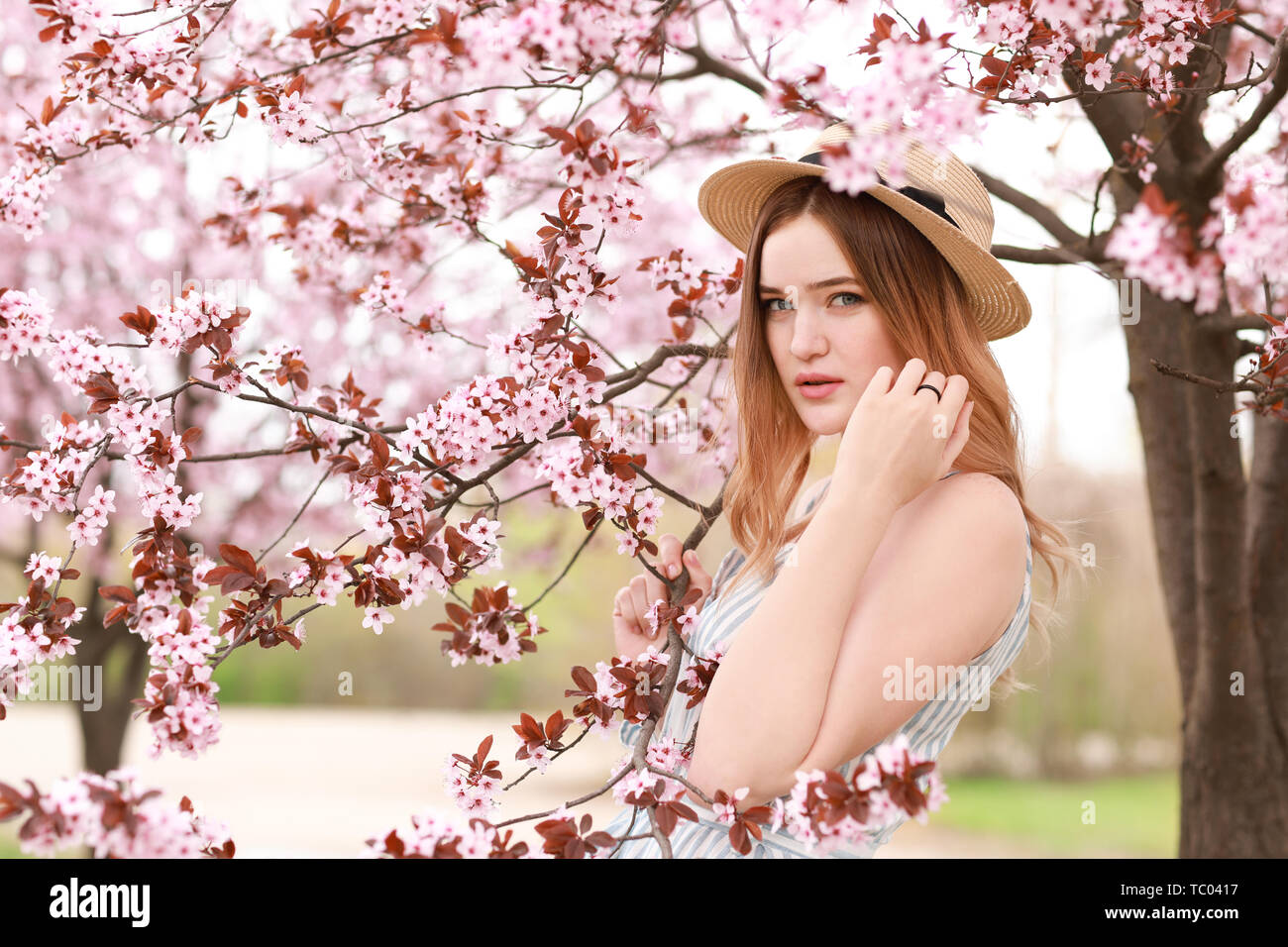 Beautiful young woman near blossoming tree on spring day Stock Photo ...